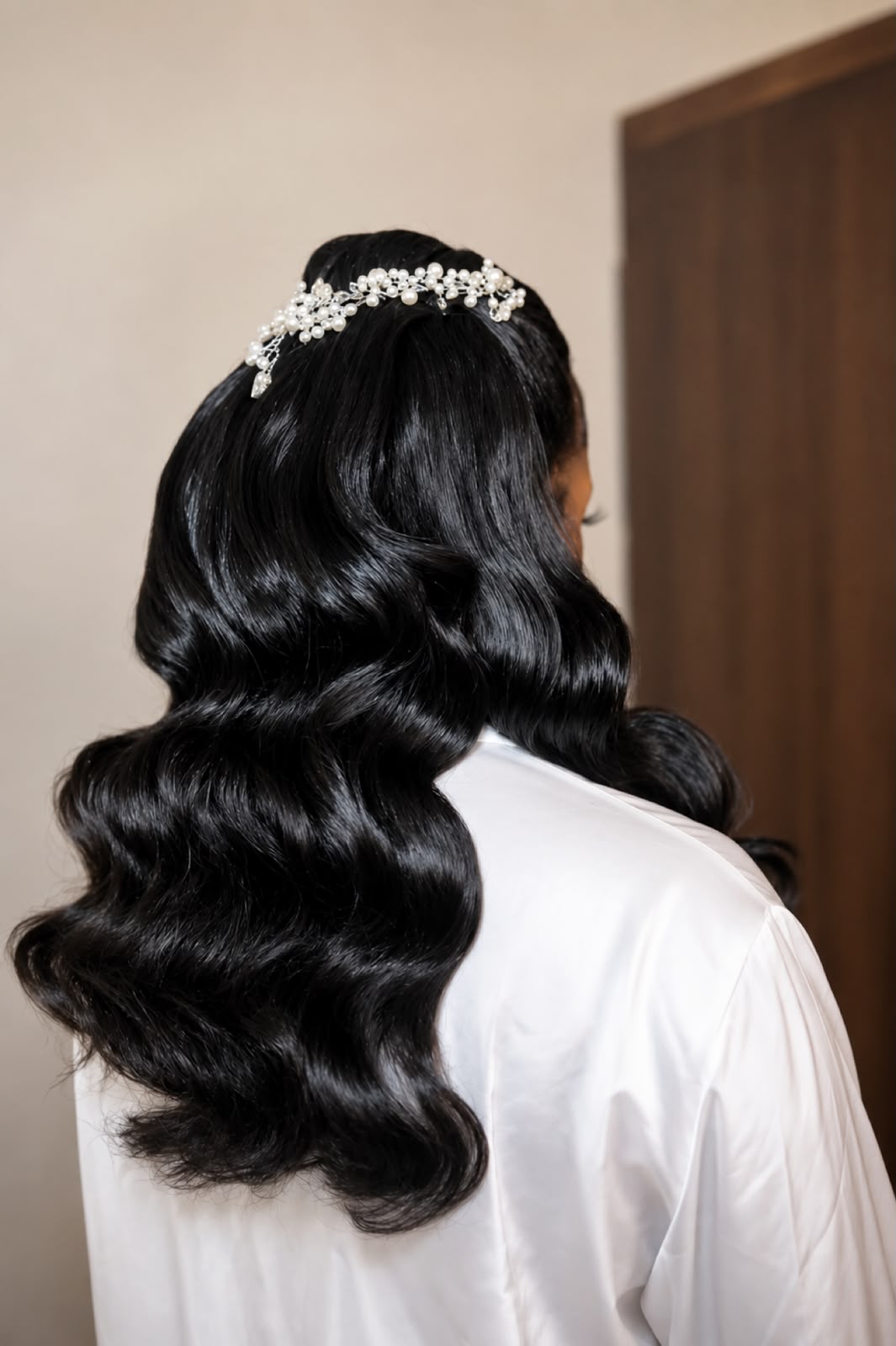 Glossy black bridal waves with a pearl hair vine