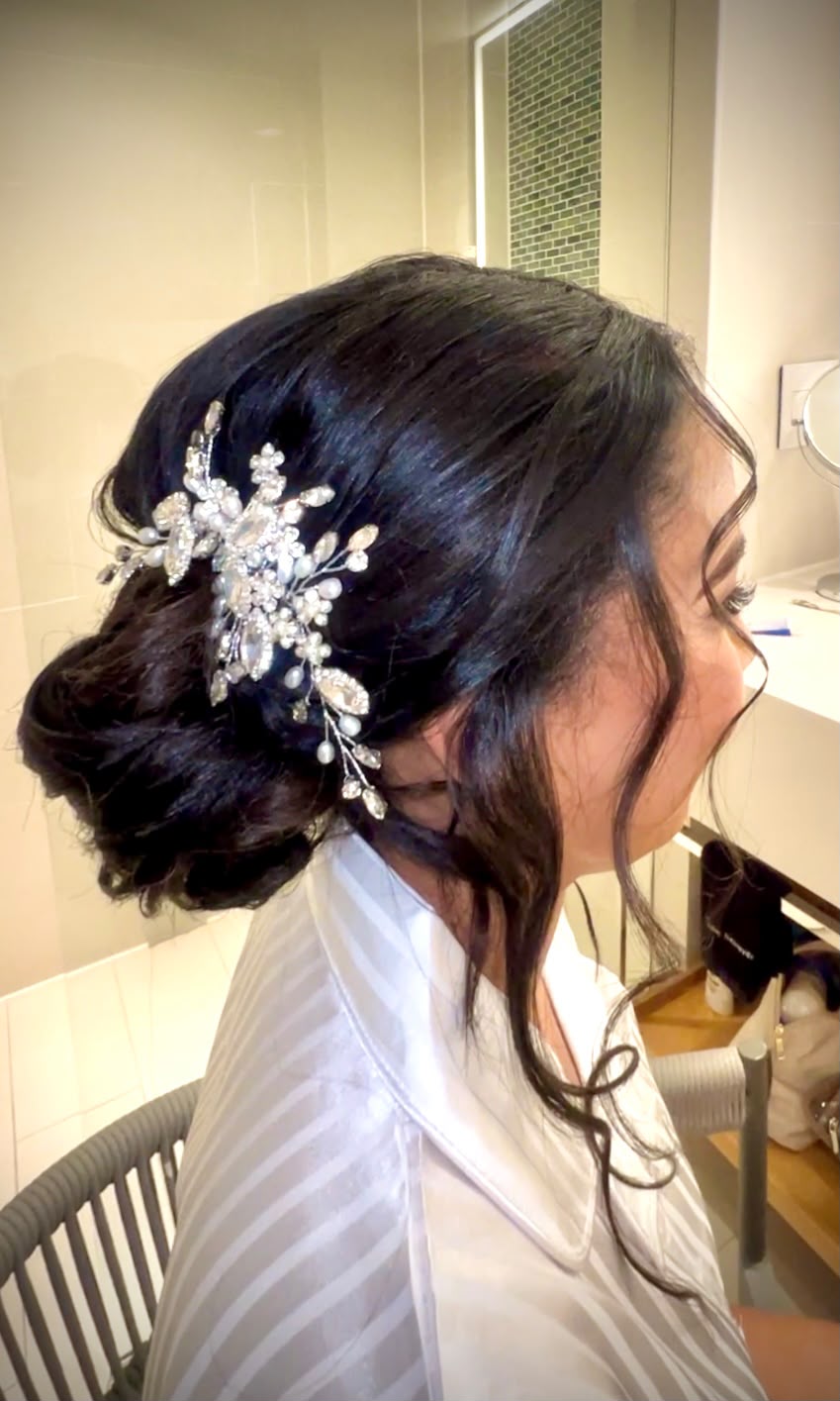 Dark low bun finished with a jewelled pearl hair comb