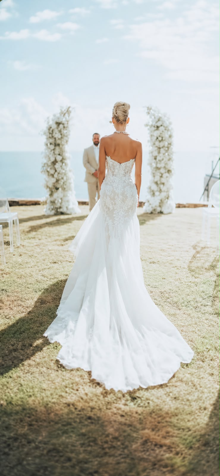 Bride walking down a clifftop aisle with a sleek blonde updo